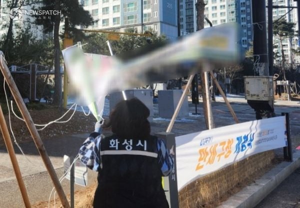 ▲화성특례시 관계자가 불법현수막을 단속