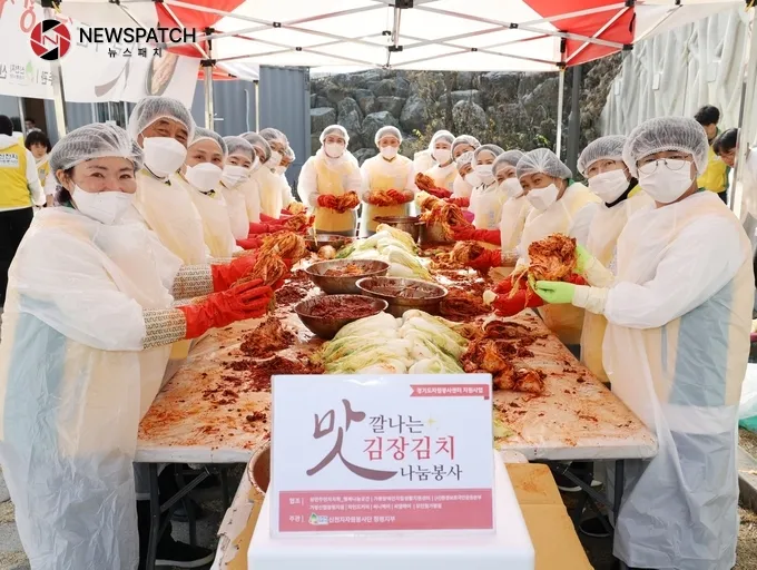 지난 23일 경기 가평군 청평생활체육공원에서 신천지자원봉사단 청평지부 봉사자들이 김장김치 속을 넣으며 사진촬영을 하고 있다.